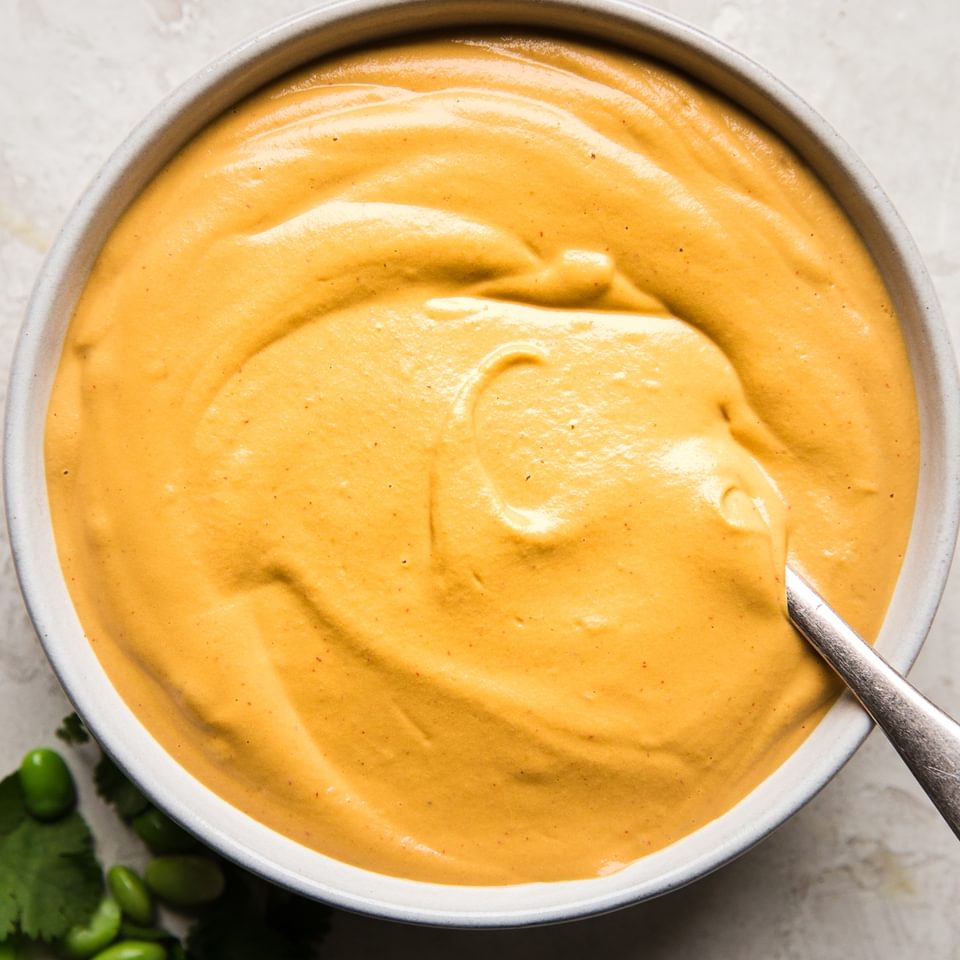 vegan cashew chipotle cream sauce in a bowl yumm sauce with a spoon