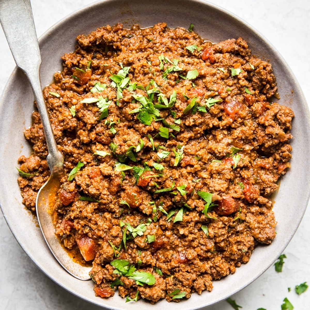 Crock pot taco meat in a bowl with spoon