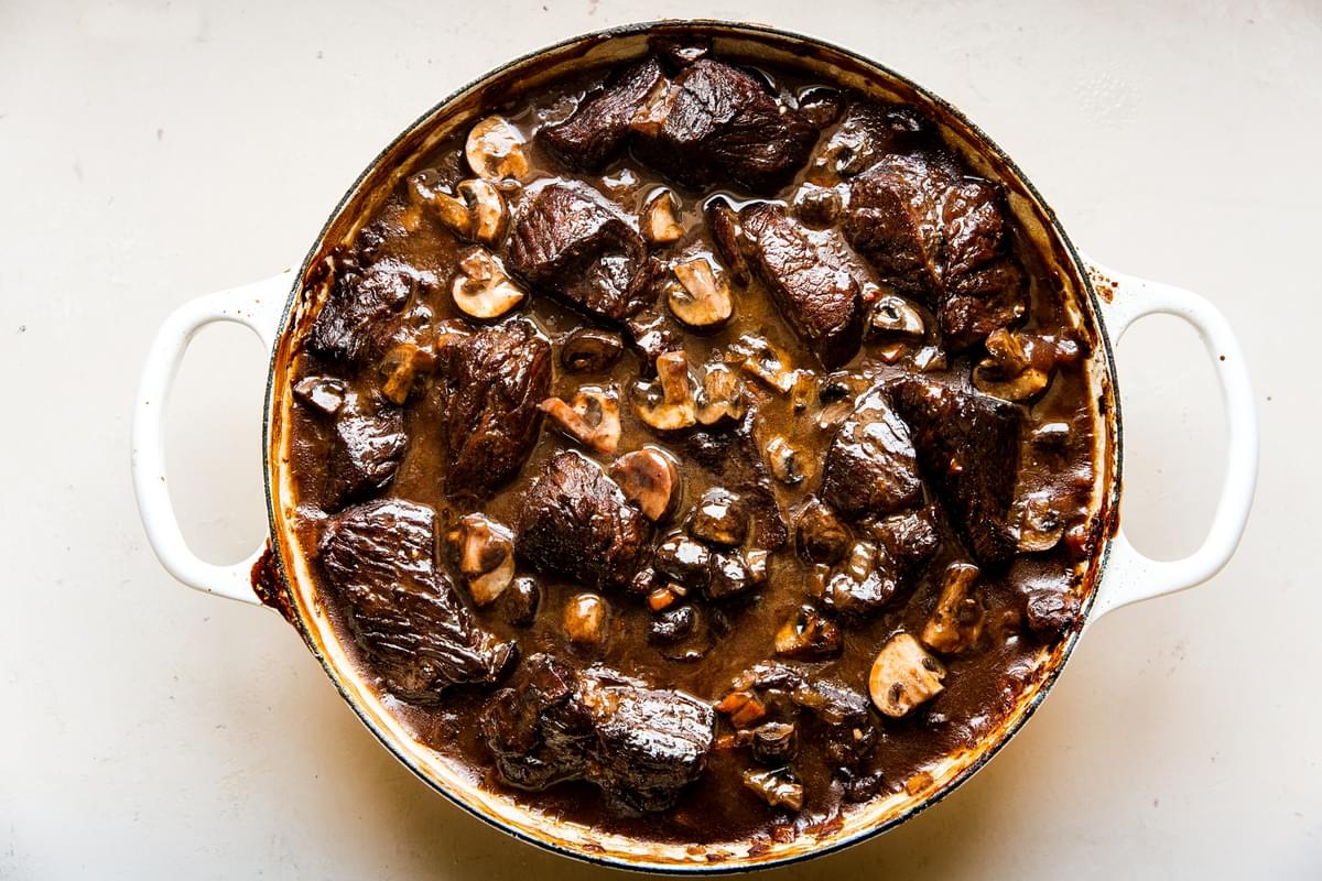 wine braised with mushrooms in a large white braiser