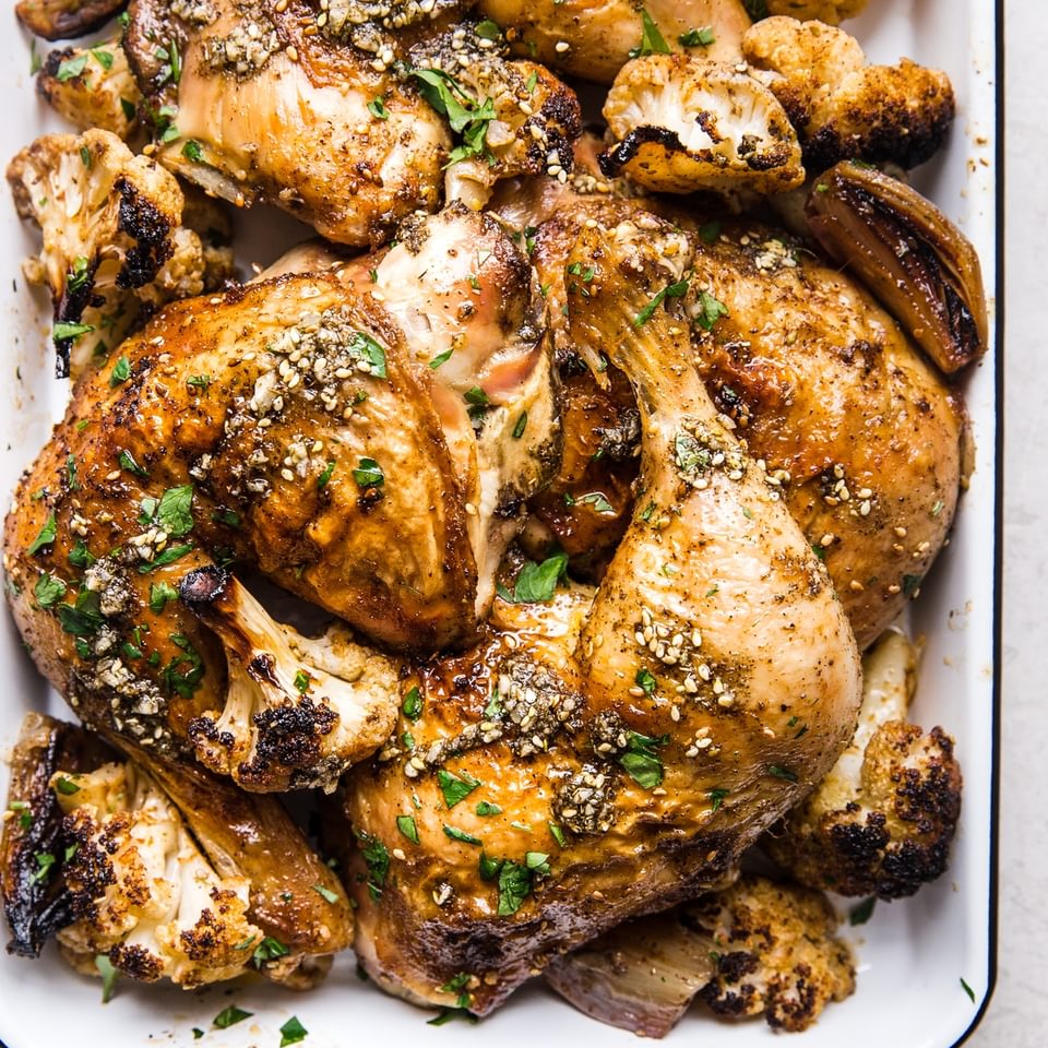 Chicken leggs with za'atar and cauliflower roasted on a sheet pan with fresh parsley