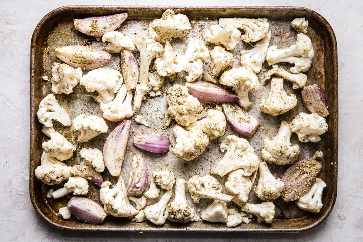 shallots and cauliflower on a sheet pan with oil and za'atar