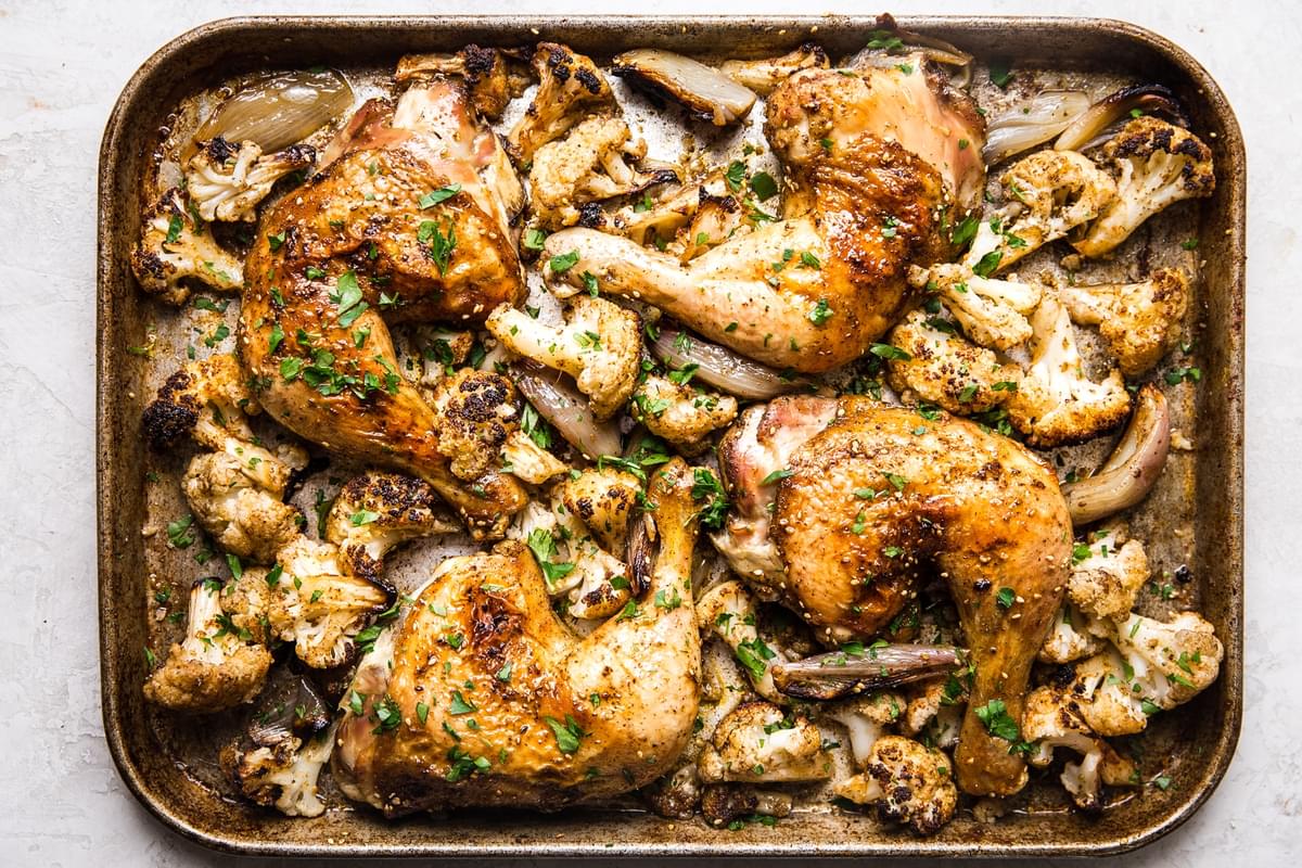 roasted za'atar chicken and cauliflower on a sheet pan topped with parsley