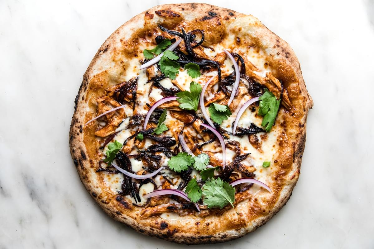 BBQ Chicken pizza topped with red onions and fresh cilantro