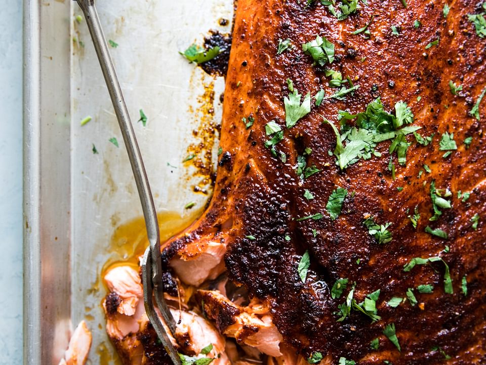 Baked salmon on a baking sheet with brown sugar paprika, garlic powder, pepper and olive oil