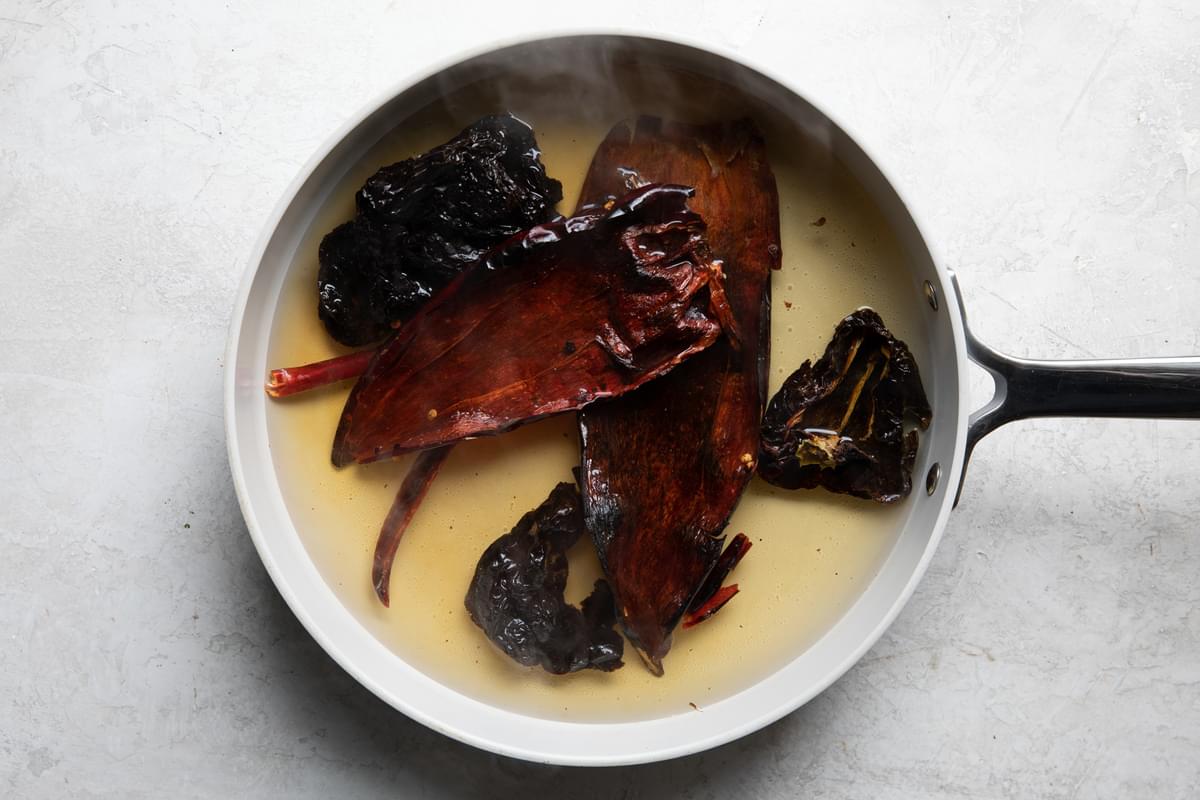 dried chiles in a sauce pan covered in water