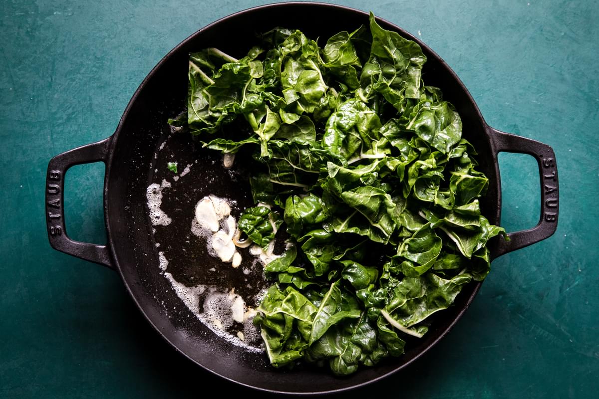 olive oil, garlic and greens in a skillet