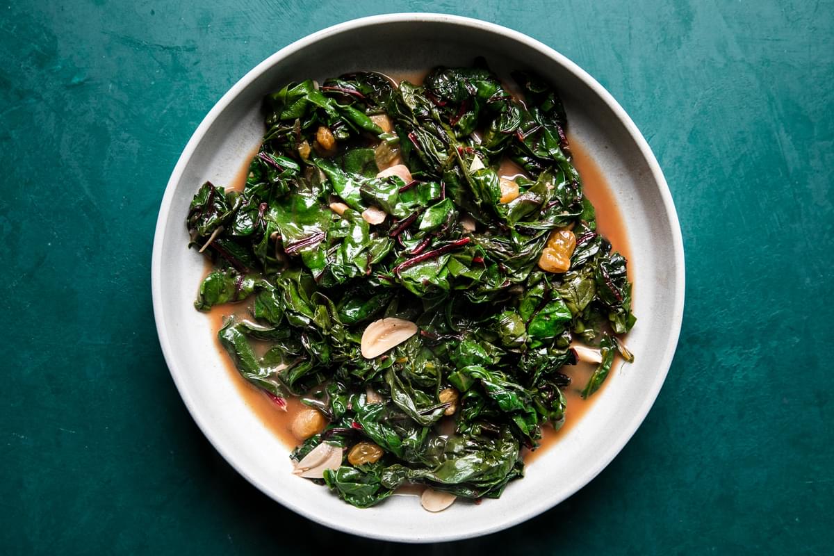 Homemade Braised Greens with Golden Raisins and Maple in a serving bowl