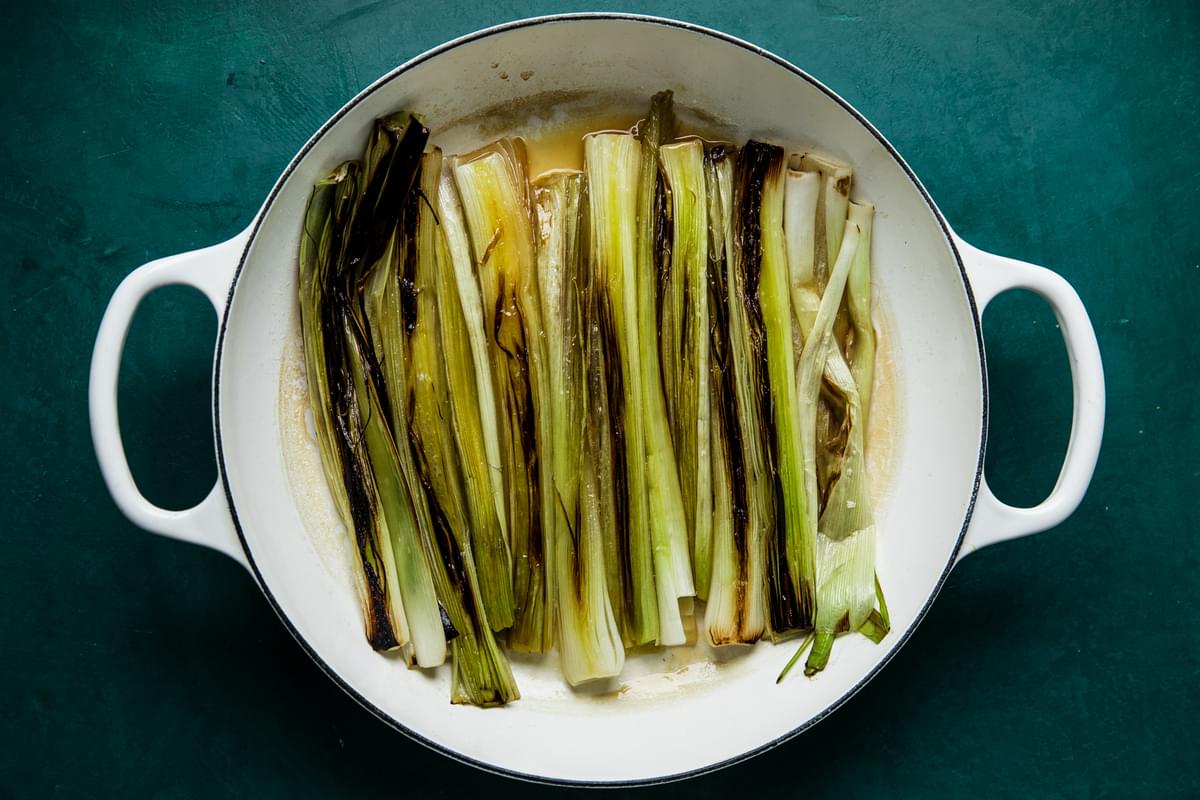 cooked leeks in a skillet with white wine, white wine vinegar and chicken stock
