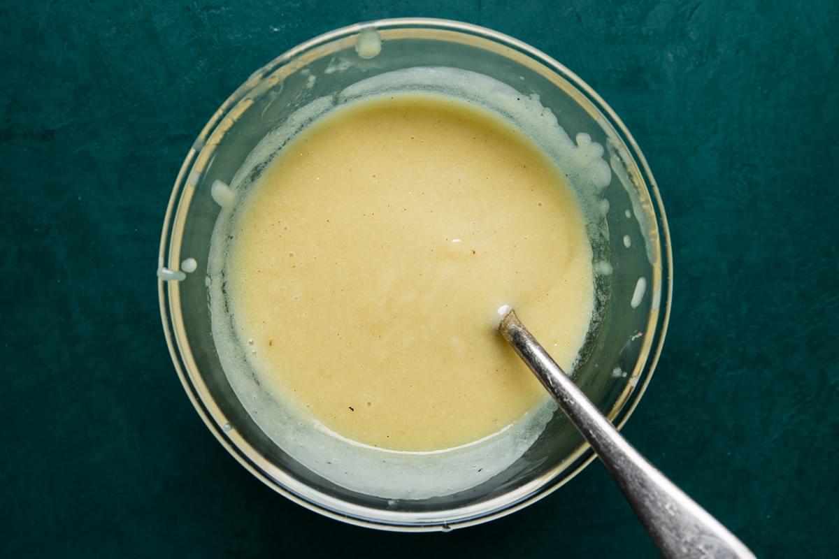 Homemade Beurre Blanc (French Butter Sauce) in a glass bowl with a spoon