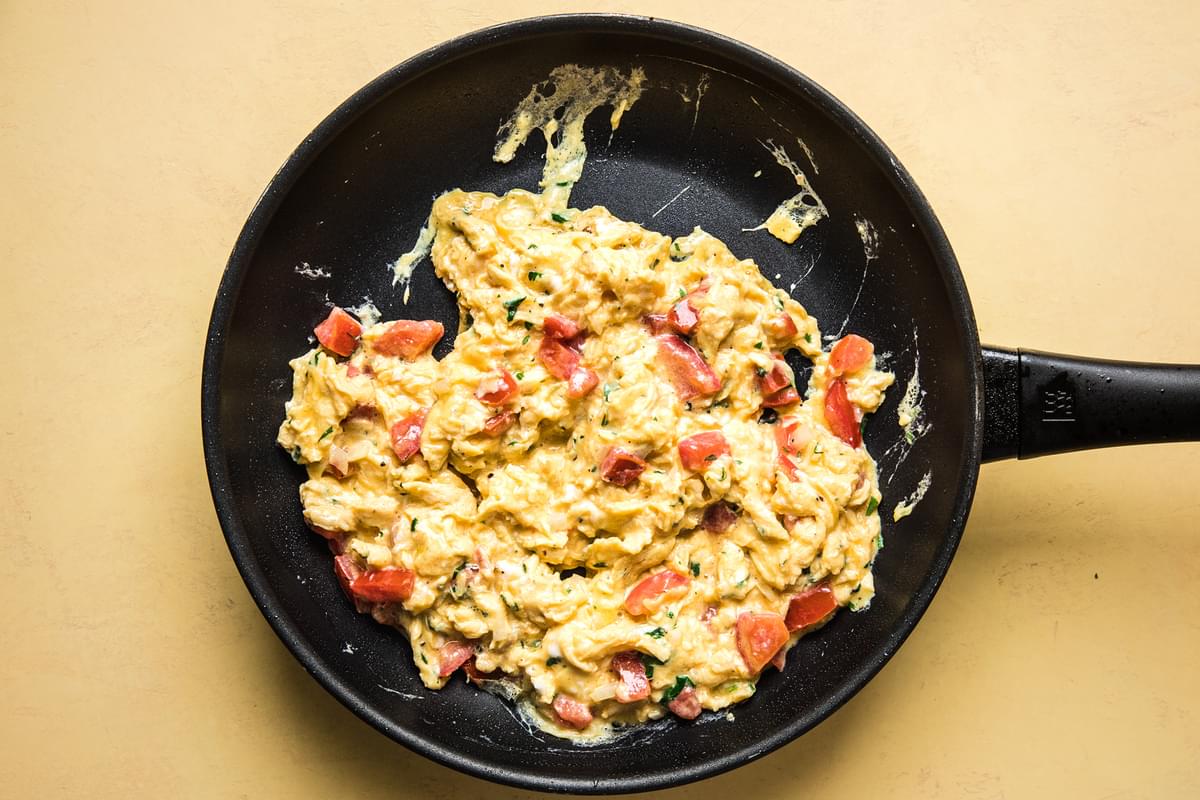scrambled eggs with pico de Gallo in a frying pan