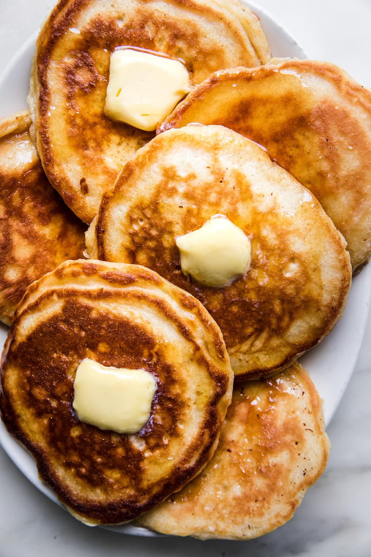 a plate of buttermilk pancakes topped with butter