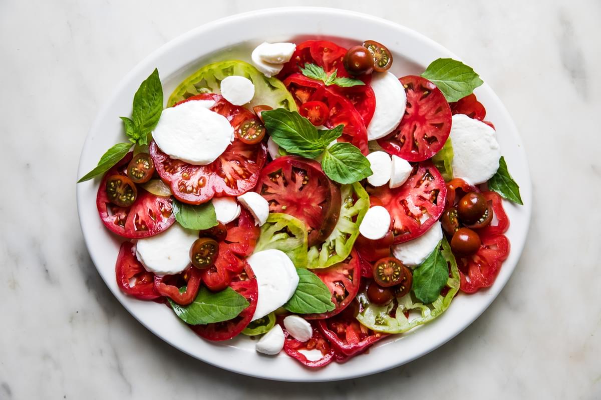 heirloom tomatoes, basil and fresh mozzarella on a plate for capers salad