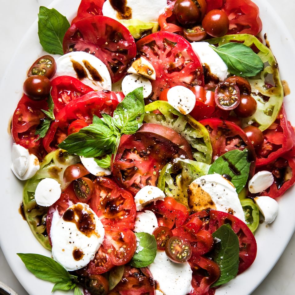 homemade caprese salad with mozzarella, tomatoes, basil and balsamic