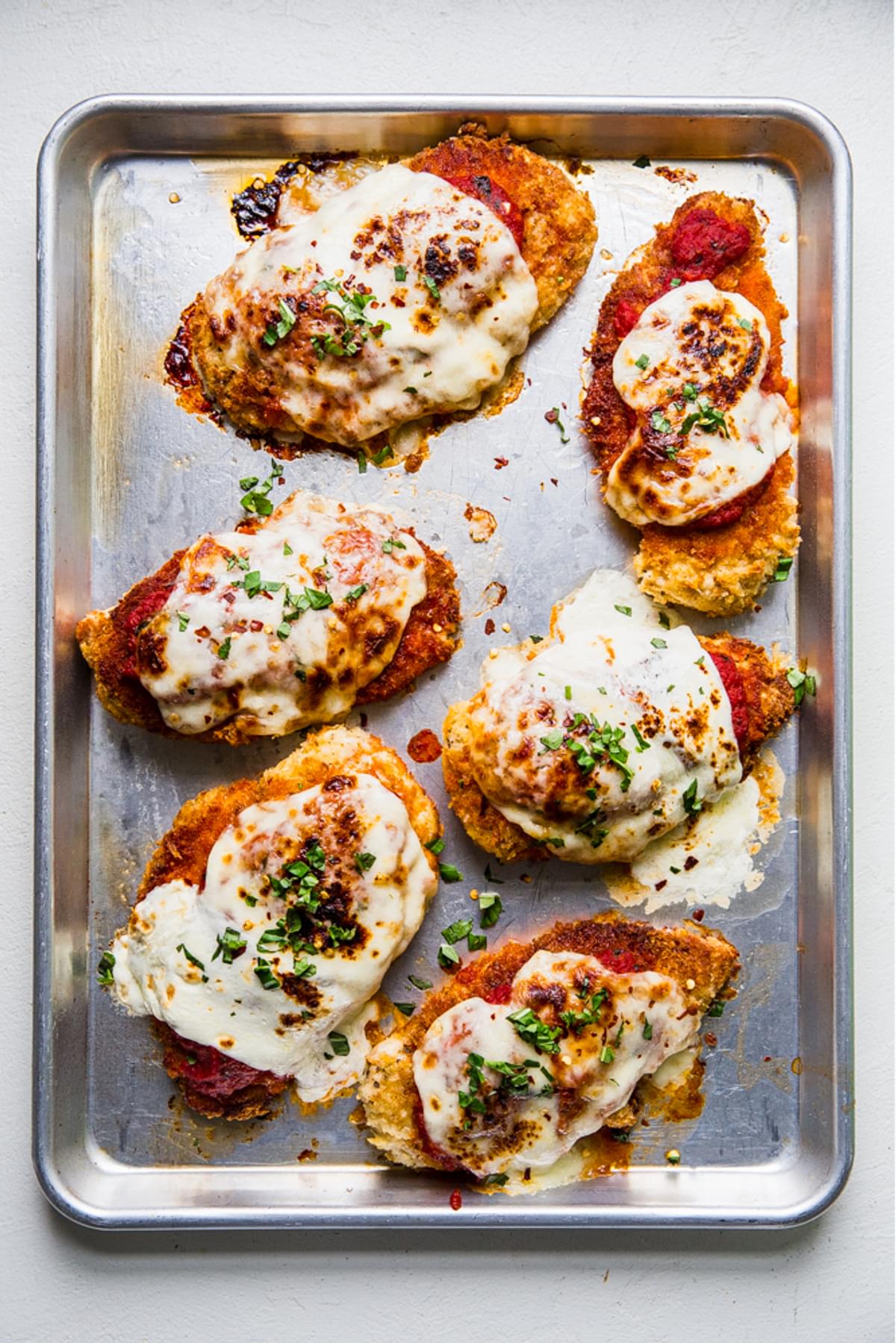 oven baked chicken parmesan with marinara, mozzarella, basil and red pepper flakes