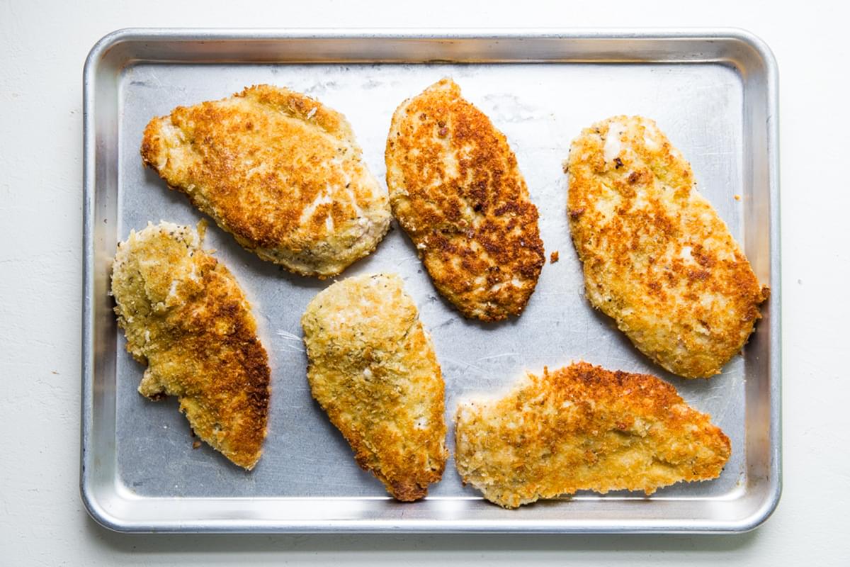 pan fried breaded chicken breast on a baking sheet