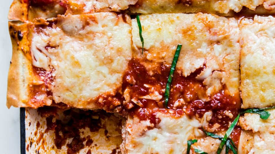 Classic Lasagna Recipe in a blue pan with a piece taken out.