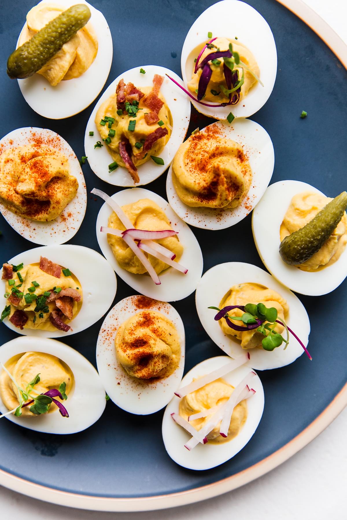 Deviled Eggs on a plate with a variety of toppings