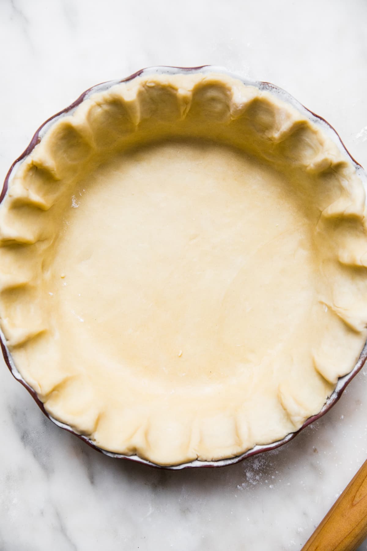 unbaked homemade Easy all-butter pie crust pressed in a pie pan on the counter