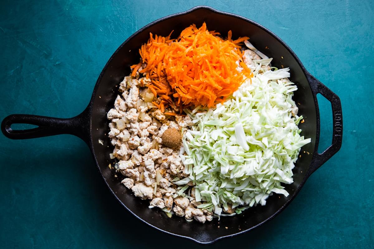 ground turkey, onions, garlic and ginger in a cast iron skillet  with carrots, cabbage and brown sugar