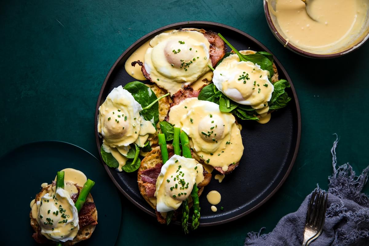 eggs benedict with hollandaise sauce on English muffins with ham and asparagus and poached eggs