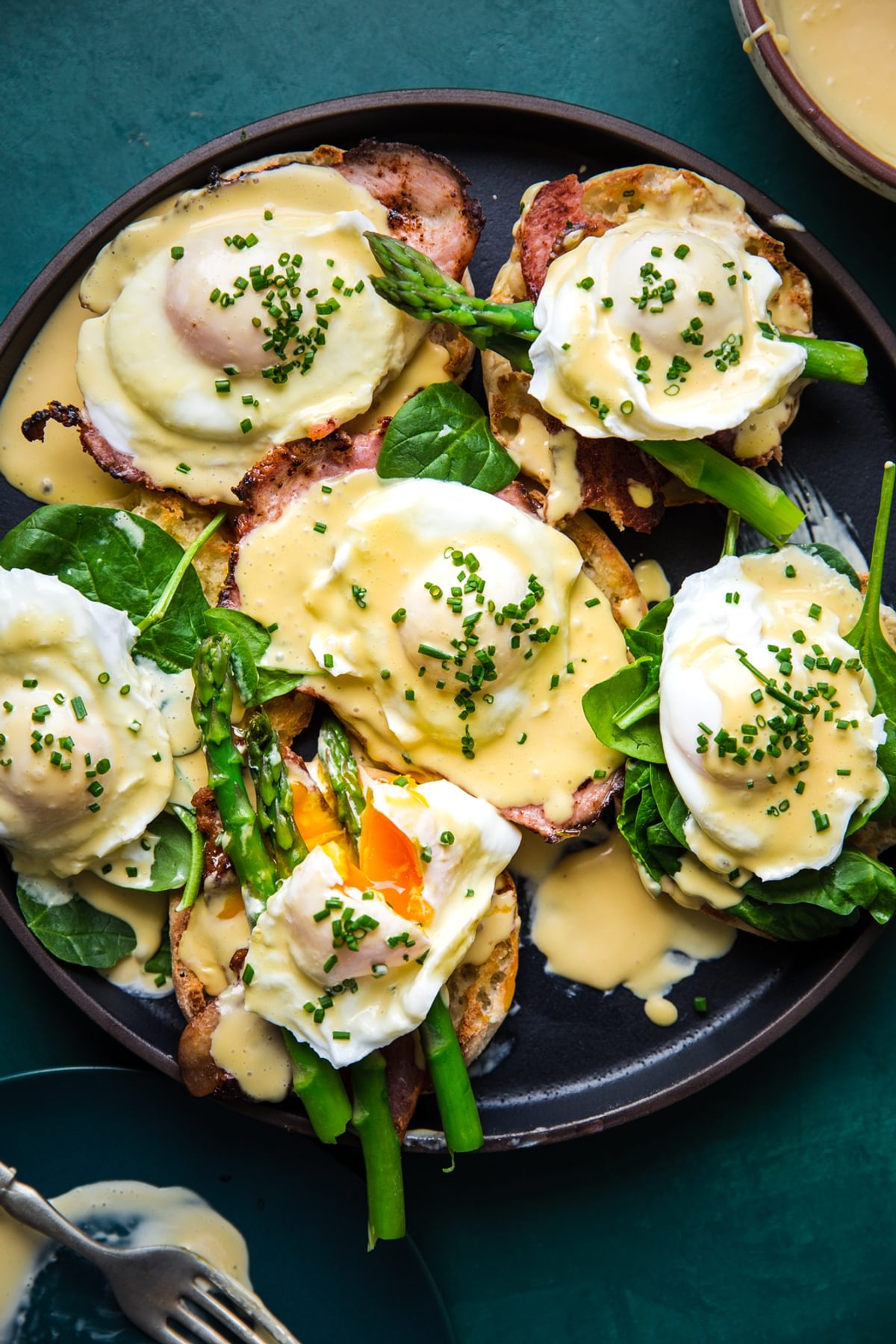 eggs benedict with hollandaise sauce on English muffins with ham and asparagus and poached eggs