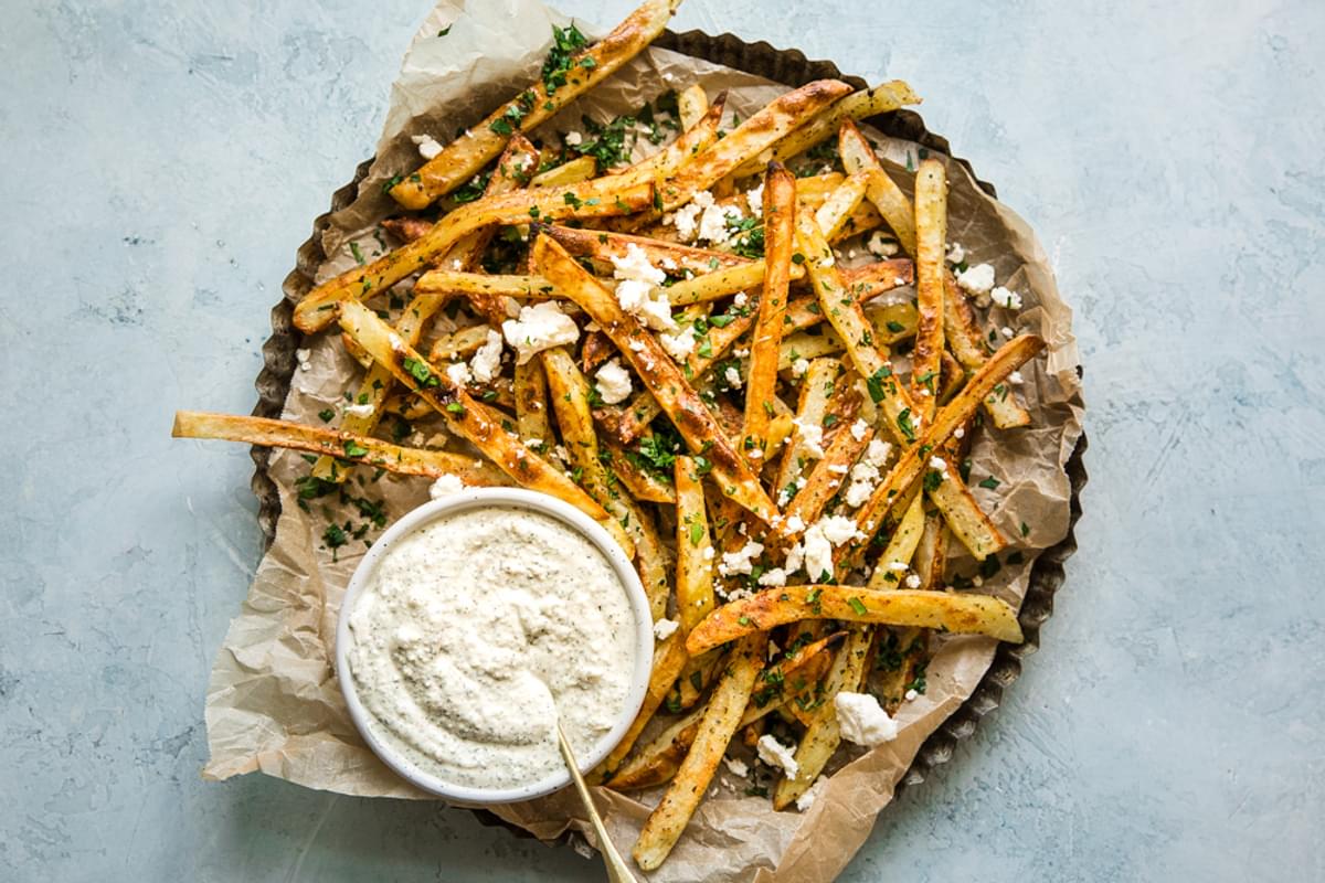 Greek Fries (Patates Tiganites) with feta dip on a plate