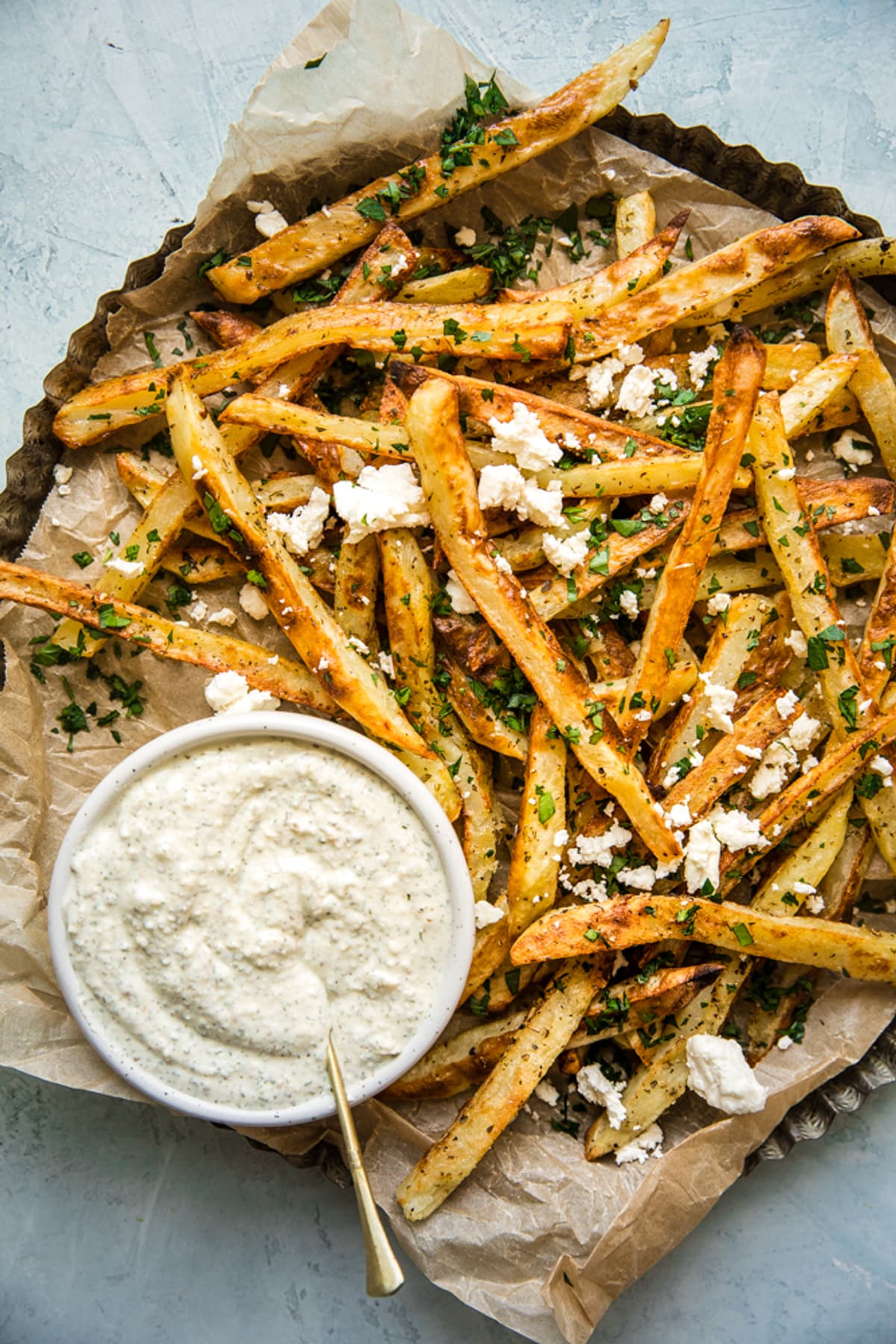 homemade Greek Fries Patates Tiganites on a plate with feta cheese dip and parsley