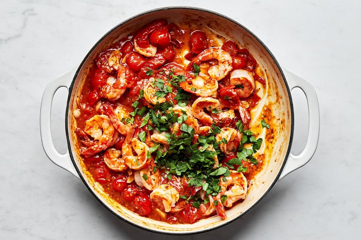 Greek shrimp in a skillet made with tomatoes, spices and fresh parsley