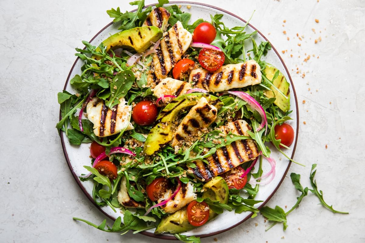 Grilled Halloumi Salad with arugula, pickled onions, avocado, tomatoes and creamy basil dressing