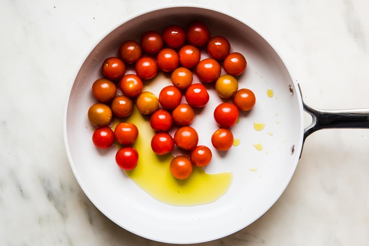cherry tomatoes in a skillet with olive oil