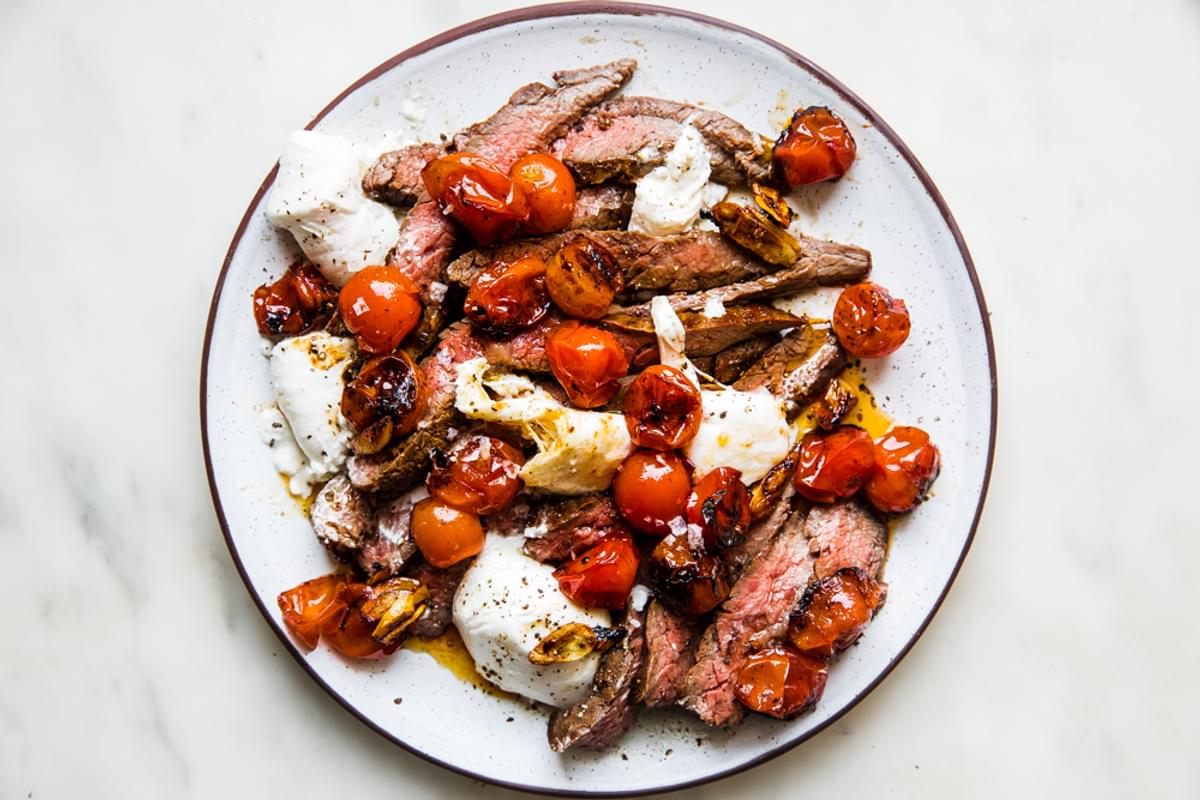 Grilled Skirt Steak with Blistered Tomatoes and burrata on a plate