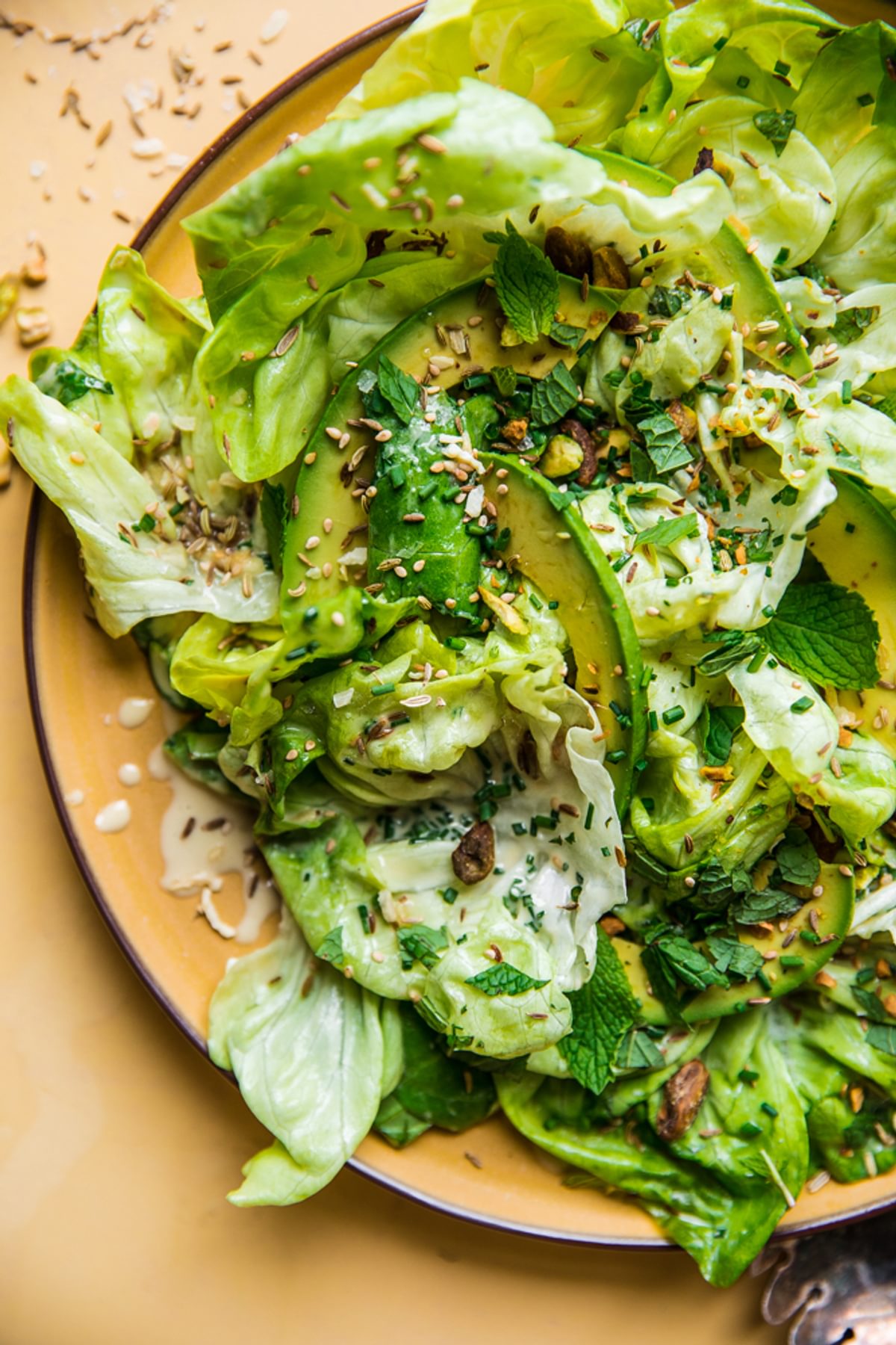Butter lettuce salad recipe with a delicious sesame tahini dressing, fresh herbs and a seed mixture