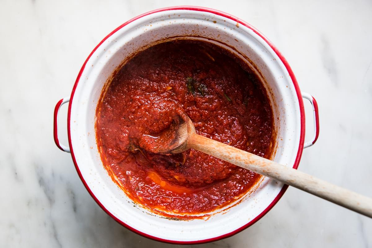 Homemade Marinara Sauce in a pot with a wooden spoon