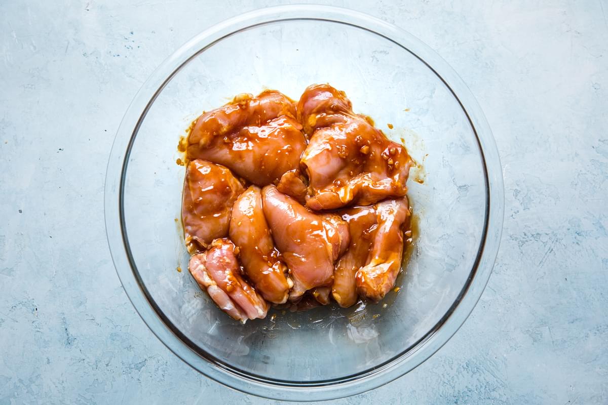chicken thighs marinating in sesame oil, ginger, garlic, soy sauce, rice vinegar, sugar, ketchup & paprika