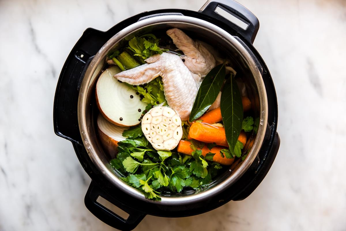 chicken wings, garlic, celery, carrots, onion, bay leaves and water in an instant pot for a chicken stock recipe