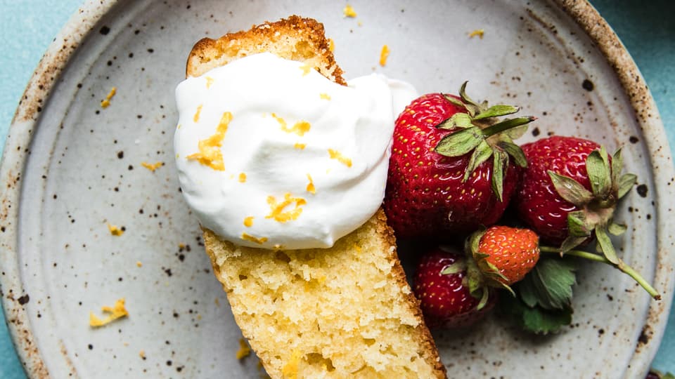 Lemon Olive Oil Cake with whipped cream and berries on a plate