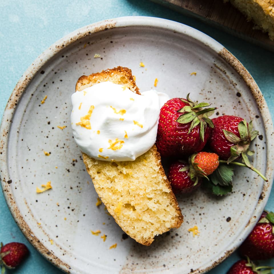 Lemon Olive Oil Cake with whipped cream and berries on a plate
