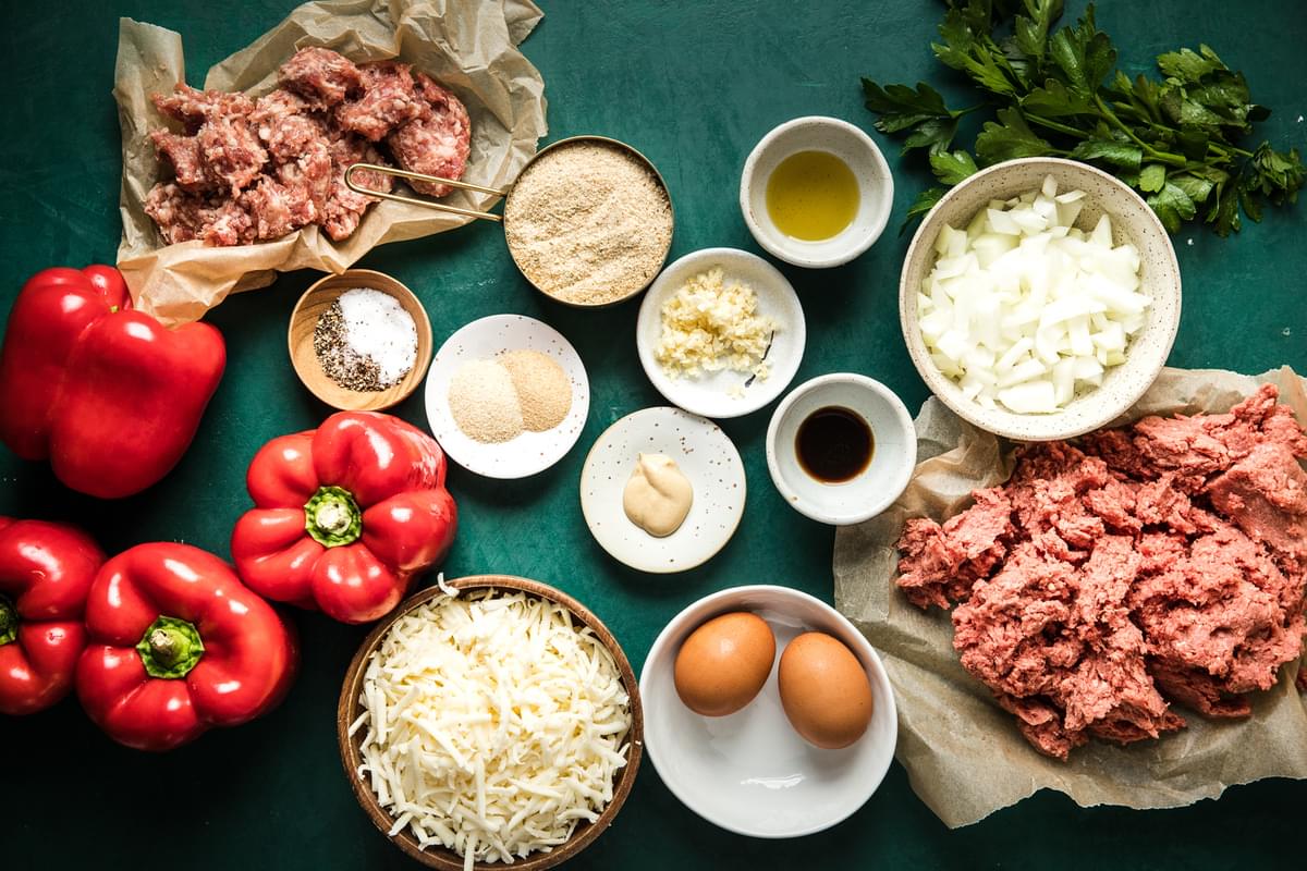 ingredients for meatball stuffed peppers laid out on the counter, eggs, ground beef, cheese and garlic
