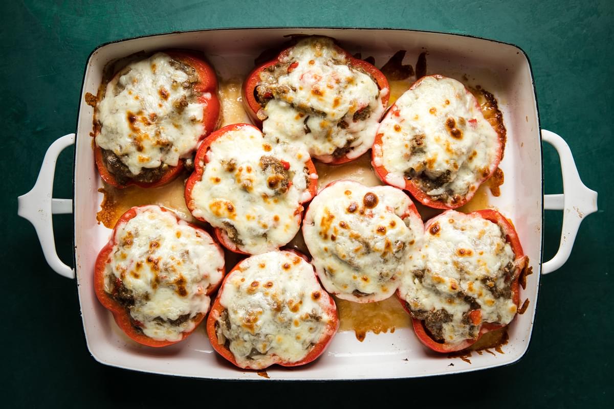 Homemade Meatball Stuffed Peppers topped with melted cheese in a baking dish on the counter