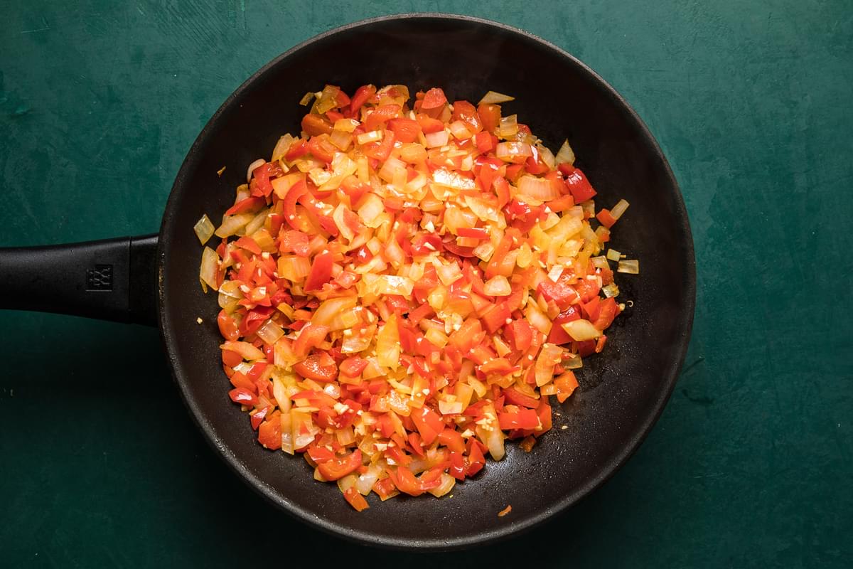 chopped bell pepper, onion and garlic in a sauté pan