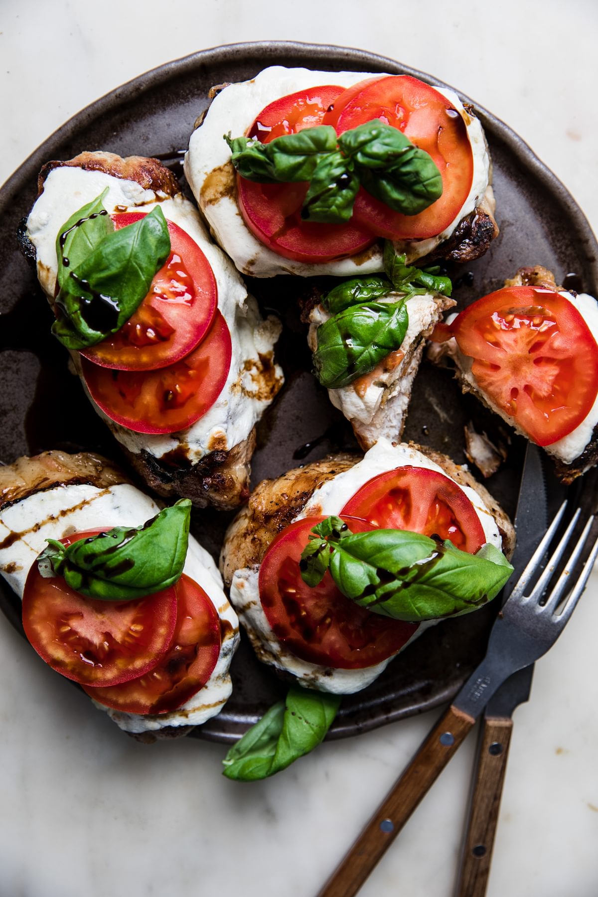 grilled pork chop caprese with fresh mozzarella, sliced tomatoes, basil and a balsamic glaze