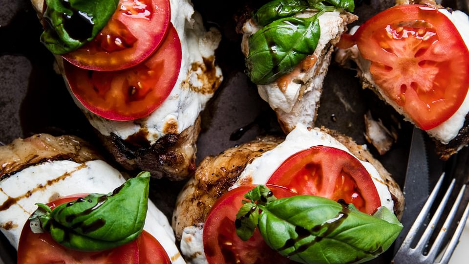 grilled pork chop caprese with fresh mozzarella, tomatoes, basil and a balsamic glaze