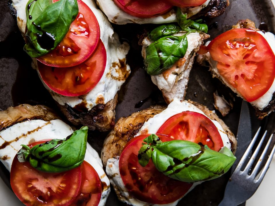 grilled pork chop caprese with fresh mozzarella, tomatoes, basil and a balsamic glaze