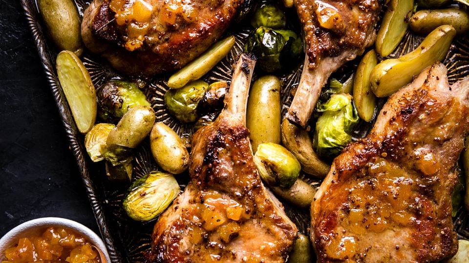 pork chops on a sheet pan with apricot dijon sauce, potatoes and Brussels