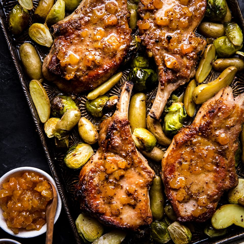 pork chops on a sheet pan with apricot dijon sauce, potatoes and Brussels