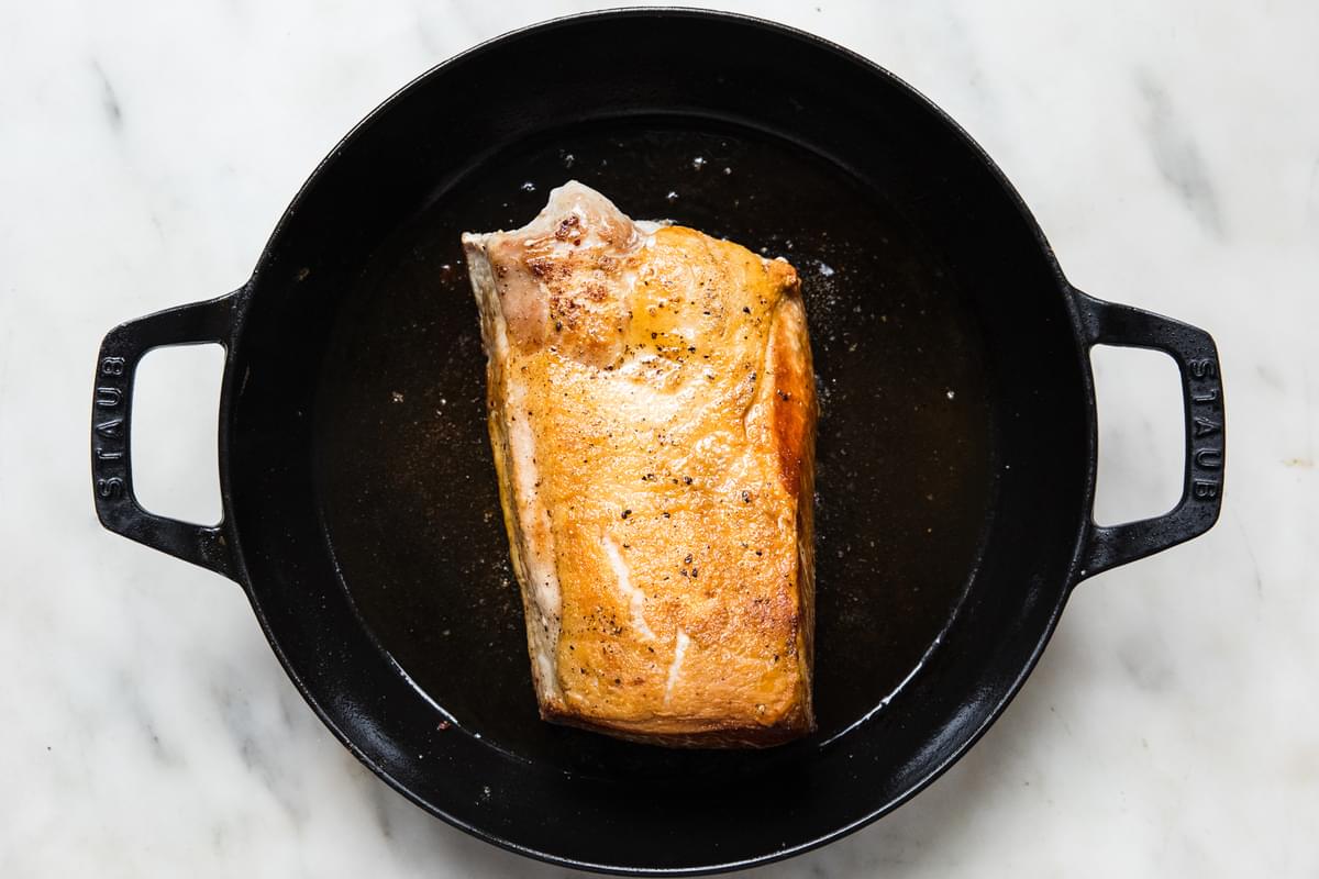 pork loin roast being seared in a dutch oven