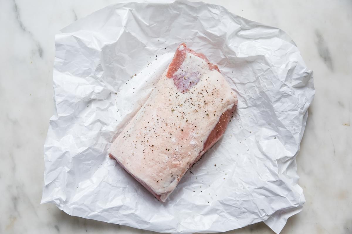 seasoned raw pork loin on a piece of parchment paper