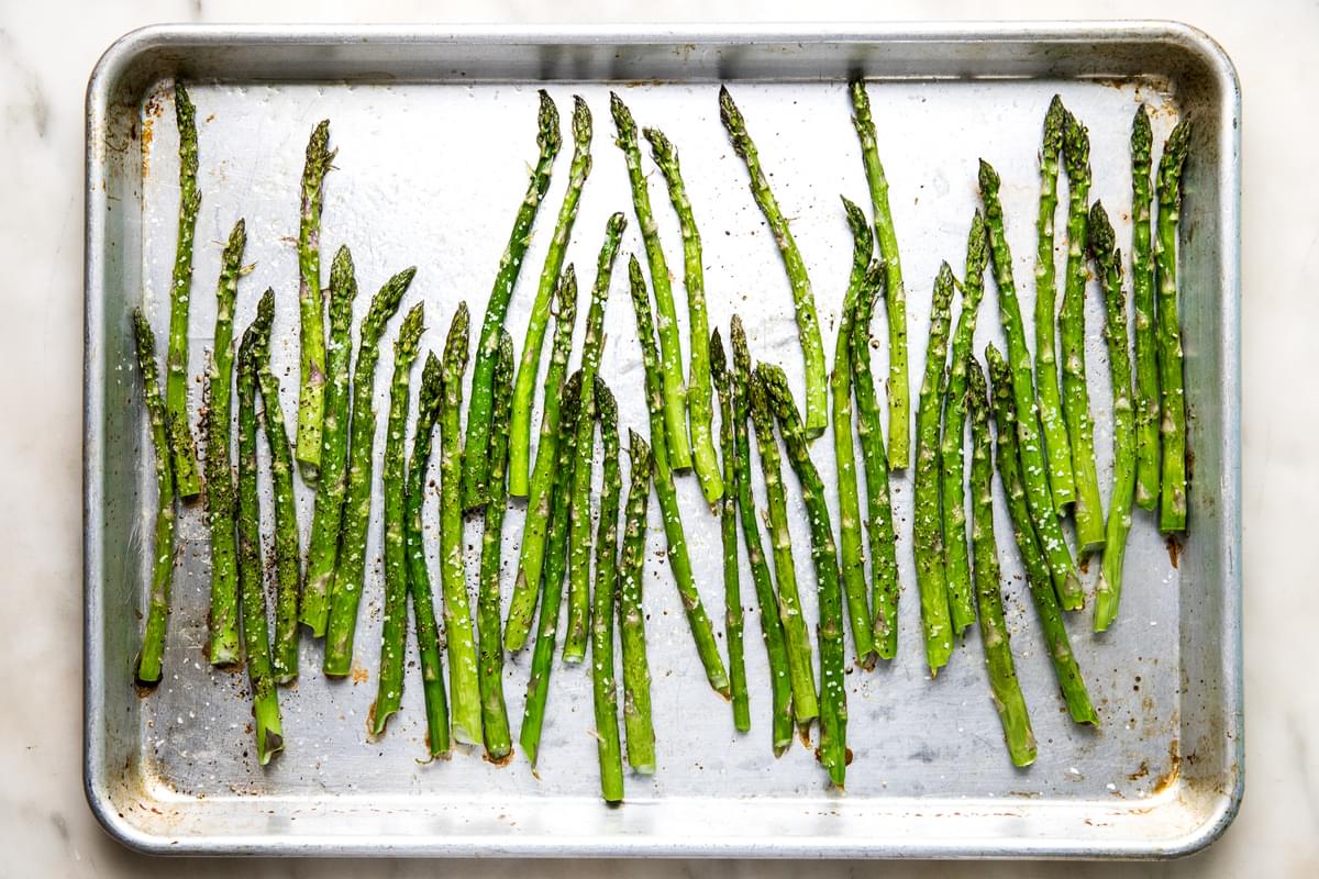 roasted asparagus tossed in olive oil, salt and pepper on a baking sheet