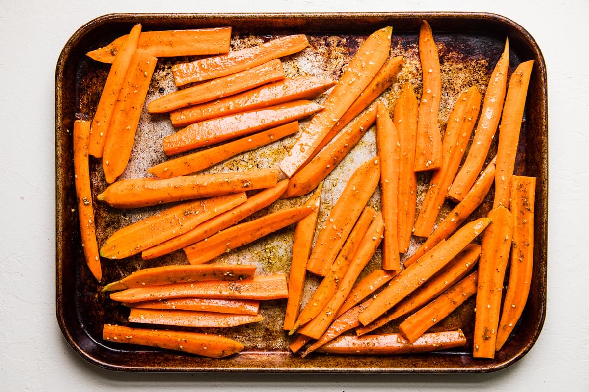 raw carrots tossed with  salt, olive oil and za’atar on a baking sheet