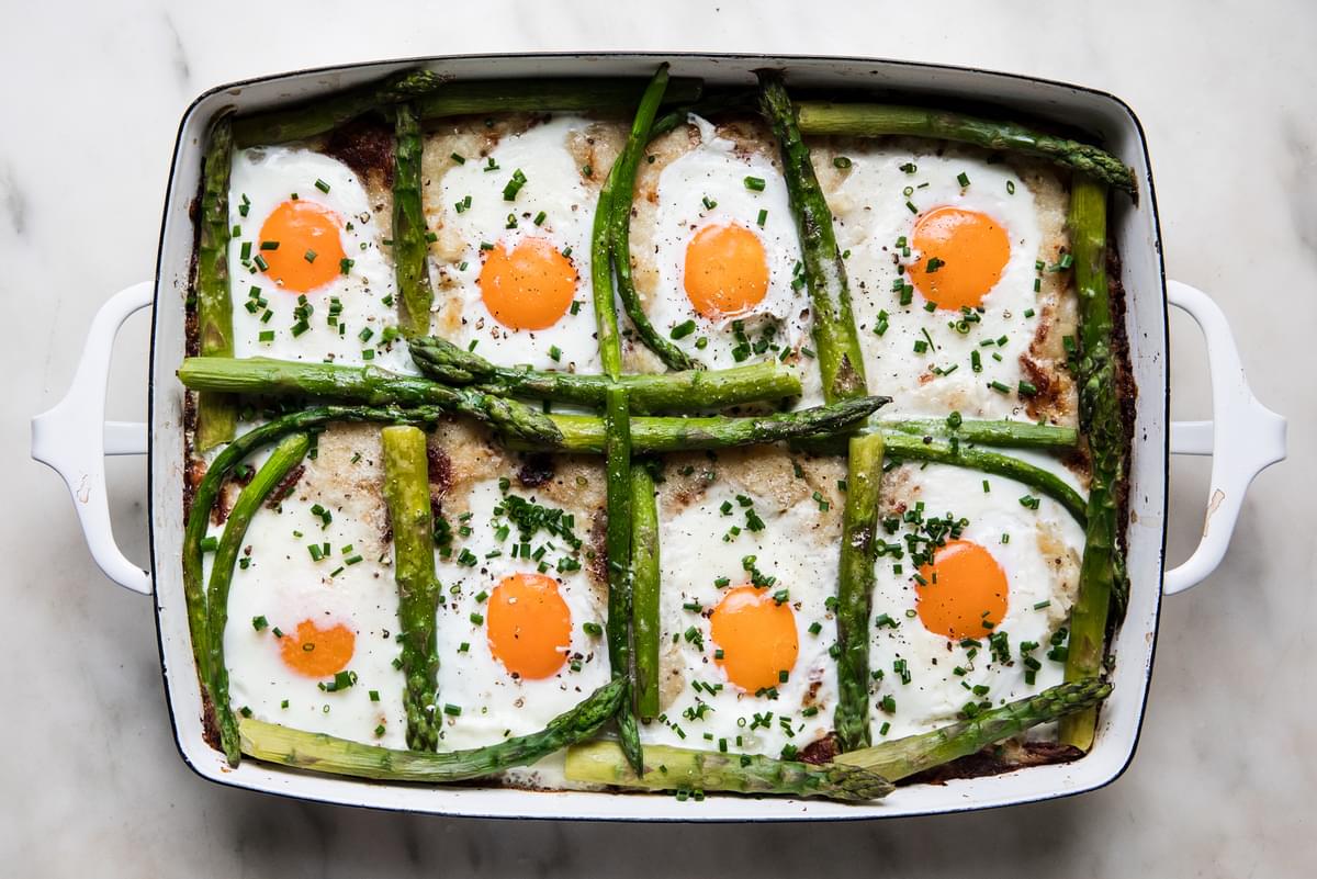 homemade potato rösti with eggs and asparagus in a baking dish